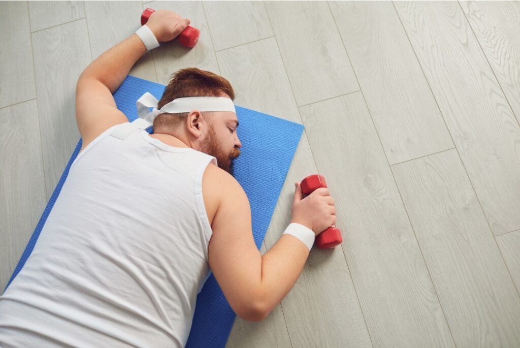 Man trying to exercise but is too tired and lying on the floor due to overexertion affecting his libido