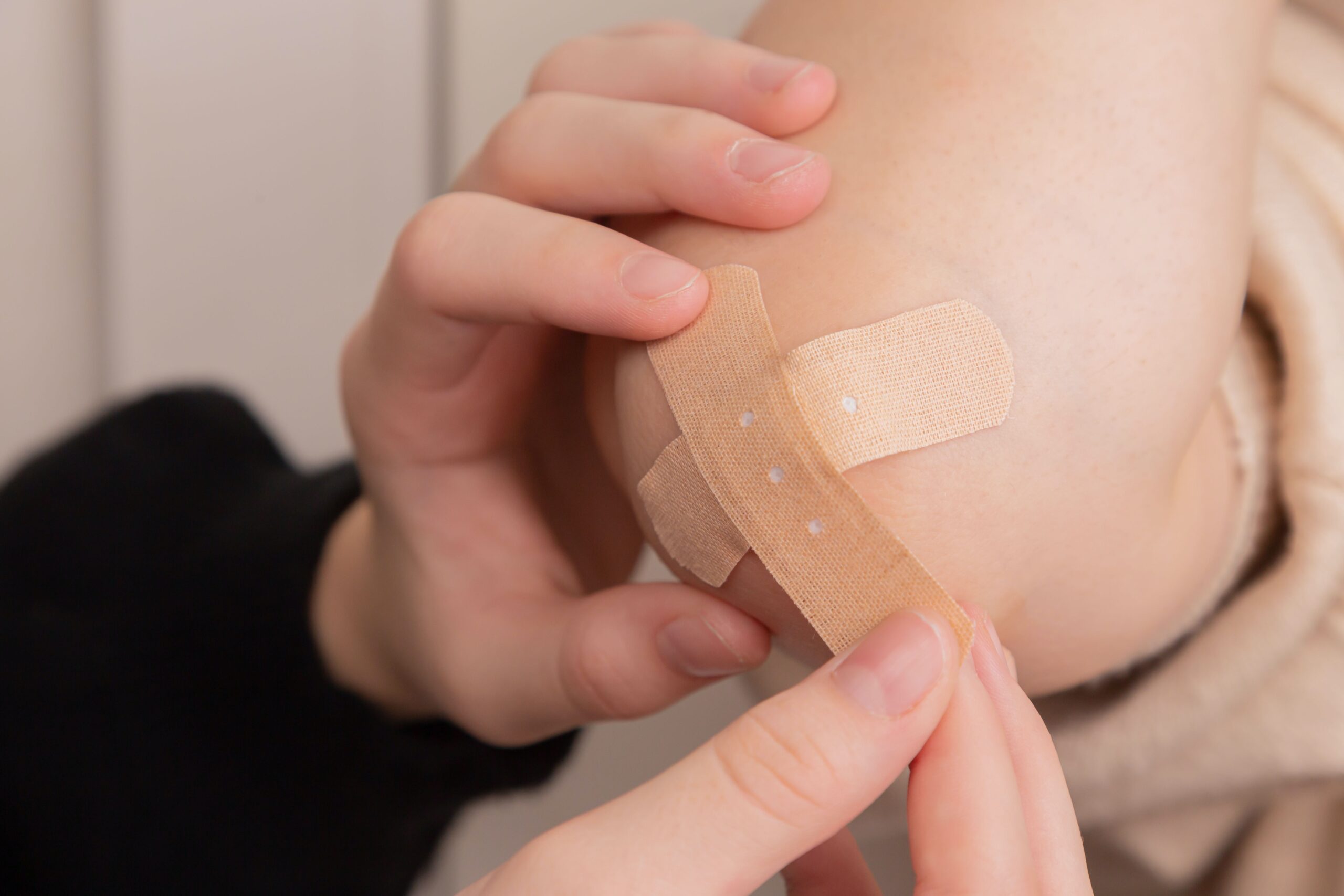 Image of bandage being placed over a scar to allow the wound to heal for a blog on scar and wound healing