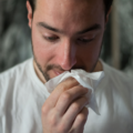 Person blowing their nose constantly due to feeling phlegmy after being sick