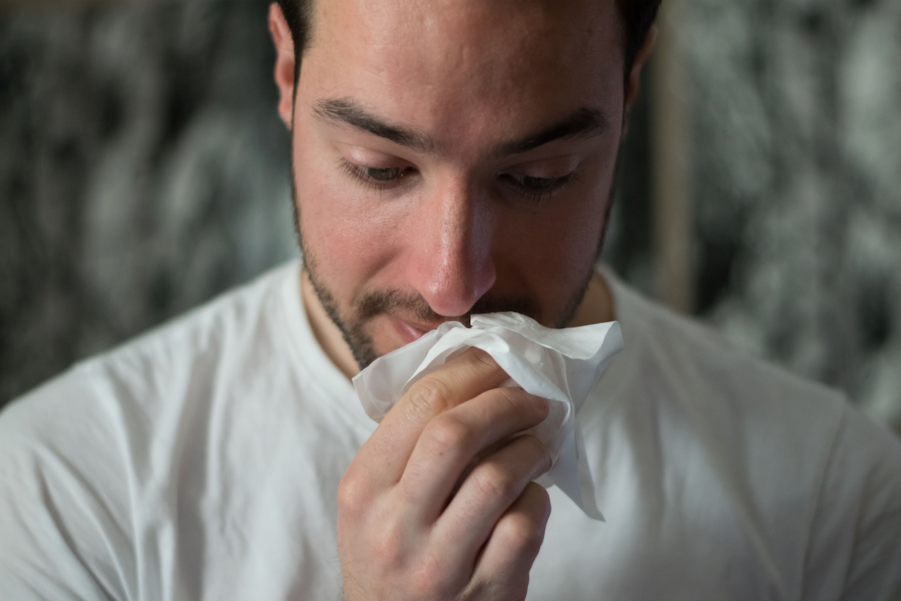 Person blowing their nose constantly due to feeling phlegmy after being sick